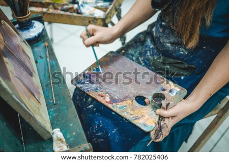 Artist painting a picture in a studio. Closeup view