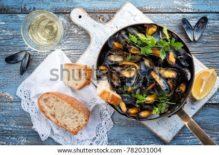 Traditional barbecue Italian blue mussel in white wine as top view in a casserole Royalty-Free Stock Photo #782031004