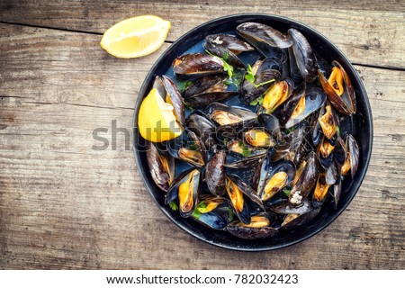 Traditional barbecue Italian blue mussel in white wine as top view in a casserole  Royalty-Free Stock Photo #782032423