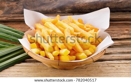 Fries fry in a basket on a wooden background. Royalty-Free Stock Photo #782040517