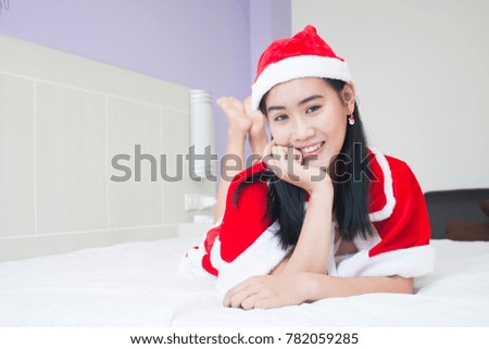 Asian  woman in Santa Claus clothes  lying on bed,Christmas concept