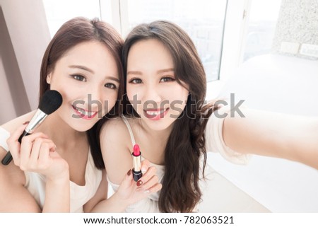 two beauty woman selfie and take lipstick with make up brush in the home