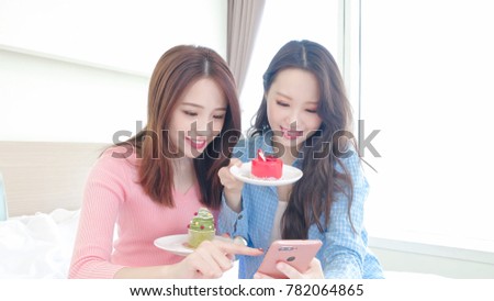 two beauty woman selfie happily and eat cake on the bed