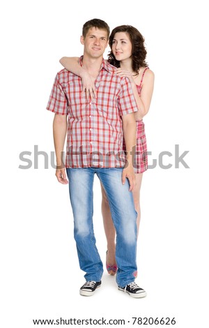 Happy young embracing couple standing on full length.