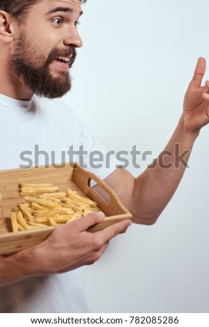 man with fast food on a light background, hamburger, potato                             