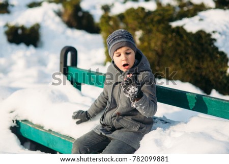 A boy warms his hands from the cold in winter