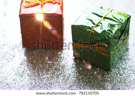 Gift wrapped box closeup on silver glitter blur background