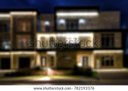 Townhouses in the night town, creative abstract blur background with bokeh effect. Lighting of house at dusk.