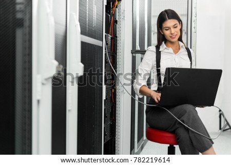Portrait of technician working on laptop in server room