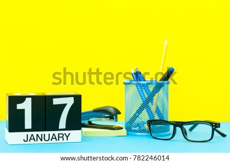 January 17th. Day 17 of january month, calendar on yellow background with office supplies. Winter time