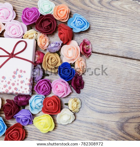 Symbol of Valentine's day. Gift box with group of roses over wooden table. Top view.