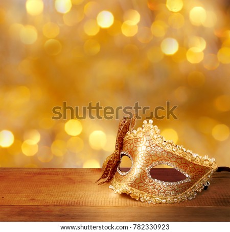 Traditional female carnival venetian mask  on table .Masquerade  mask on  glitter background.Mardi Gras.