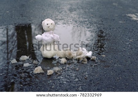 melted snow and snowman in puddle, natural background. bad rainy winter weather, anomaly weather concept. autumn, winter, spring time. beginning or end winter season