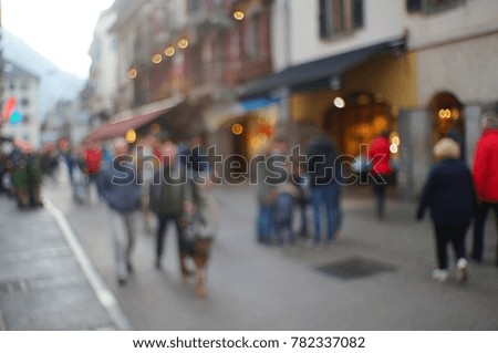 Blurred picture of a city pedestrian street with people walking along it. Blurry. Out of focus.