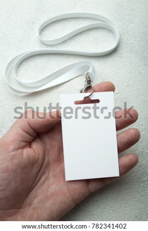 Empty name tag with white strap in hand, mockup.