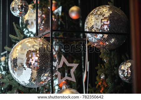 New Year's decorations of a festive banquet with golden stars, glass shiny balls and green branches of a Christmas tree
