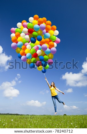 Happy young woman holding colorful balloons and flying over a green meadow Royalty-Free Stock Photo #78240712