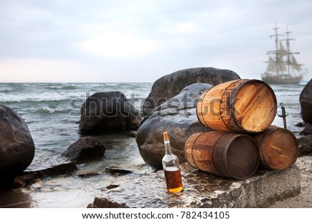 A pirate backdrop with rum and barrels on the beach, and a pirate ship behind