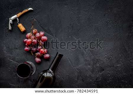 Open the wine. Corkscrew near bottle on black background top view copyspace
