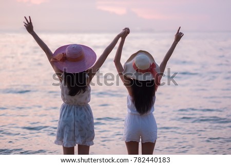 Silhouette of young beautiful tourist women selfie with smartphone during sunset at beach. Portrait of Happy traveler asian women using Smartphone for Selfie with Happy emotions,