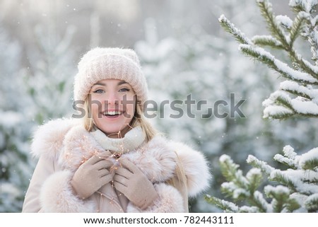 Portrait of pretty girl near a spruces in a winter