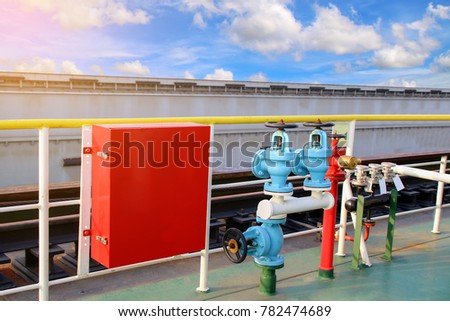 Fire hose cabinet Box with fire fighters equipment axe and hydrant valve on blue sky background 