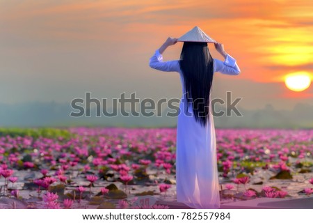 Asian girl in national costume of Vietnam Standing backon the boat in Red lotus sea in Undon Thani, Thailand. Unseen in Thailand Royalty-Free Stock Photo #782557984