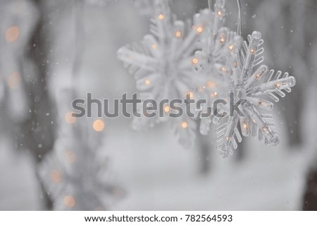 Snowflakes decoration, hanging Christmas lights during snowfall.