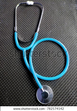 Light blue Stethoscopes for Nurse in carbon fiber background