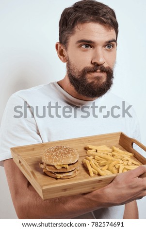man with, fast food, a tray, a hamburger, a potato                               