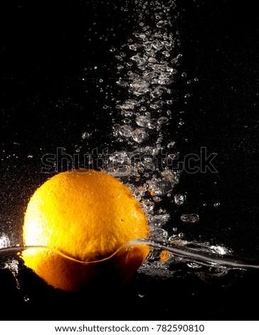 Orange under water on a black background