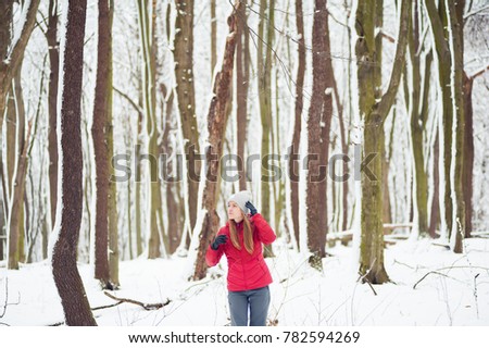 Beautiful girl walking in the winter forest