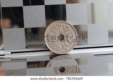 Denmark coins in mirror reflect wallet lies on wooden bamboo table background Denomination is 5 krone (crown) - back side