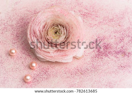 Sequined pink rose put on an old paper in background, with rose pearls

