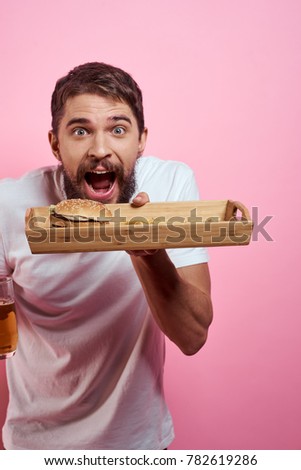  man holding a tray with fast food on a pink background                              