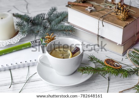 A festive winter mock up photo with a fir twigs, an opened note book, an old book, a pencil, cones, a candle and decation elements