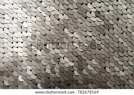 Texture of silver shiny sequins close-up macro abstract background. Fashionable expensive bright fabric with sequins.