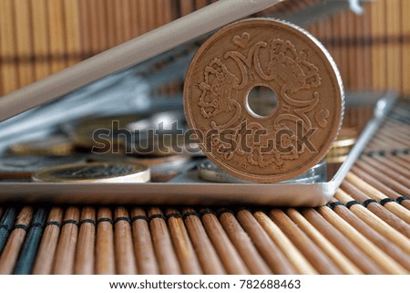 Pile of Denmark coins in mirror reflect wallet lies on wooden bamboo table background Denomination is 5 krone (crown) - back side