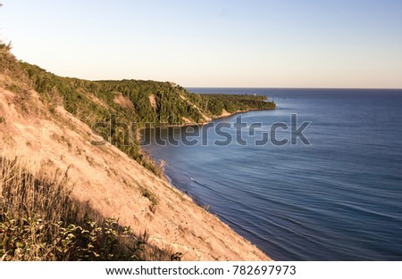 Lake Superior Coast. Massive sand dune towers above the blue water of Lake Superior in the Pictured Rocks National Lakeshore in Grand Marais, Michigan, USA.
