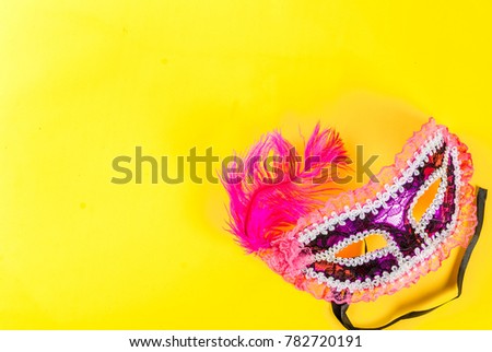 Mardi gras background with holiday mask, on bright yellow background copy space top view