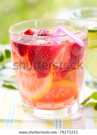 cold fresh lemonade drink with strawberry and lemon close up. Selective focus