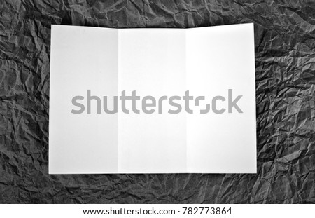 Empty window fold flyer at a grey wrinkled paper background