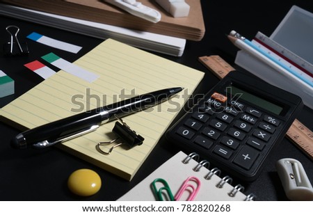 Close up of office business supplies on black background in studio. Basic and classic office business supplies. Set of school supplies concept.