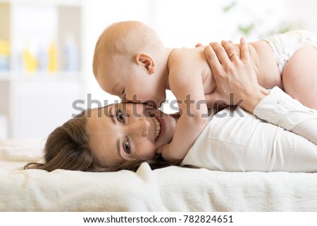 Adorable baby kissing his mother. Young woman and little child have a fun pastime. Royalty-Free Stock Photo #782824651
