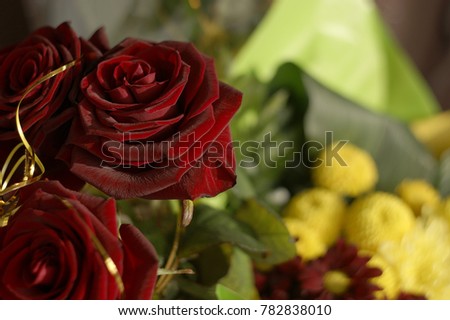 red roses and yellow chrysanthemums are folded into a bouquet