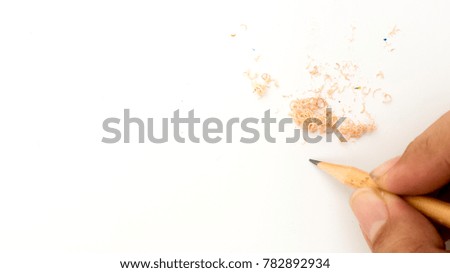pencils placed on the surface with sharpener chips with hand
