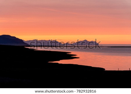 Sunrise at the black diamond beach near Vik in Iceland with mountains in the background during summer time.