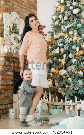 Happy boy with mather near Christmas tree