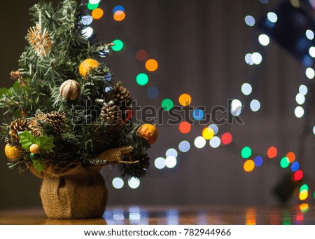 Christmas tree on wooden table, colorful lights on background, new year