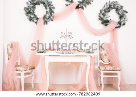 New Year's decor. christmas wreath. New Year's table. New Year. christmas table. gently pink room. christmas wreath over the table

